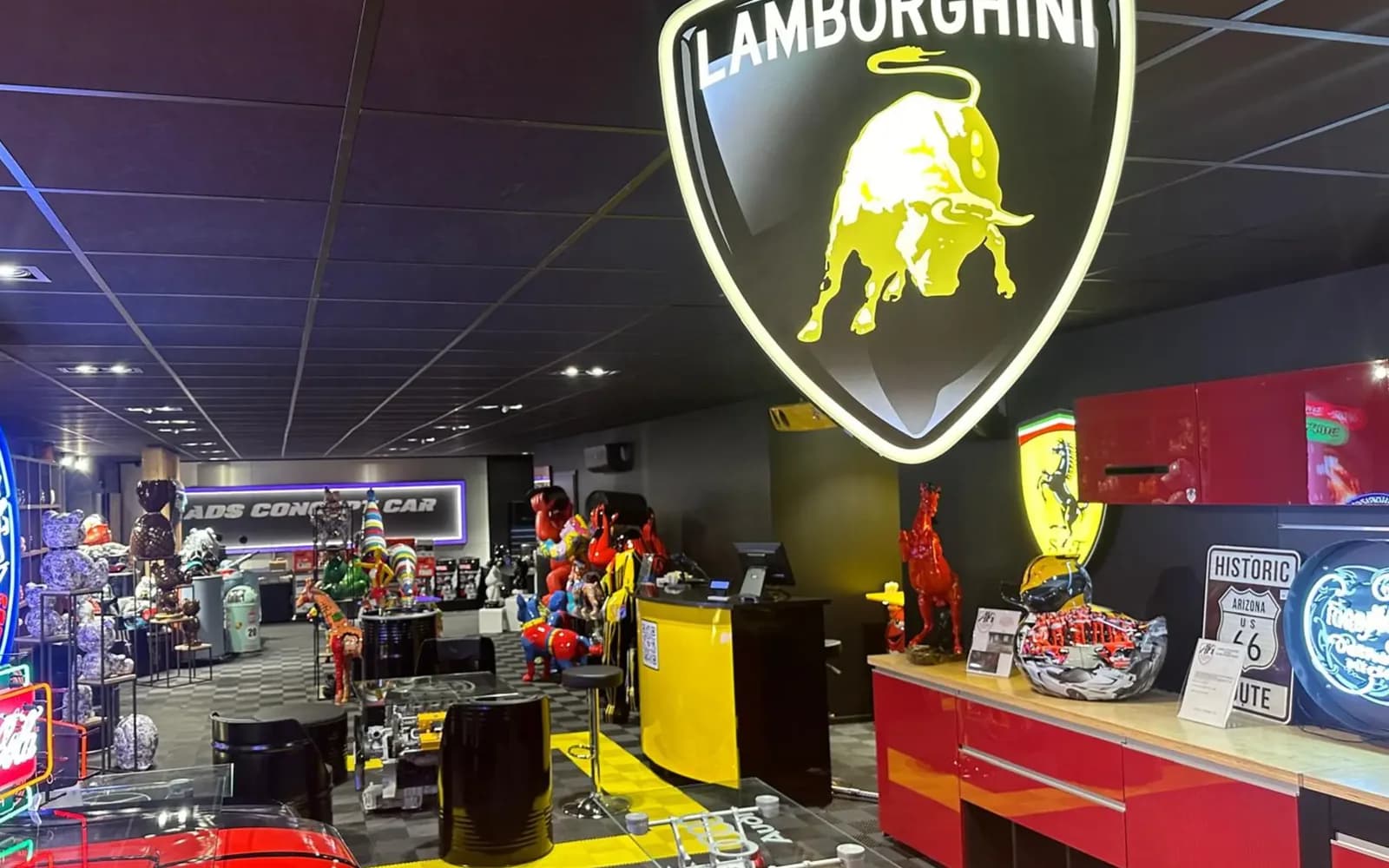 Comptoir de la boutique ADS Concept Store sous l’enseigne lumineuse Lamborghini